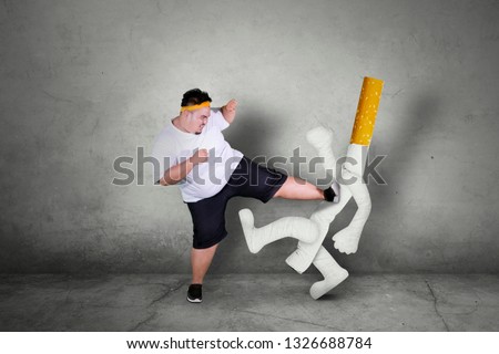 Picture of an Asian obese man wearing sportswear while kicking a cigarette. Quit smoking concept.