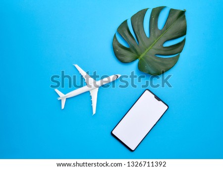 Design of leaves Monstera. Concept,search for creative ideas on the Internet White smartphone on light blue background,  Empty space for copy, text,