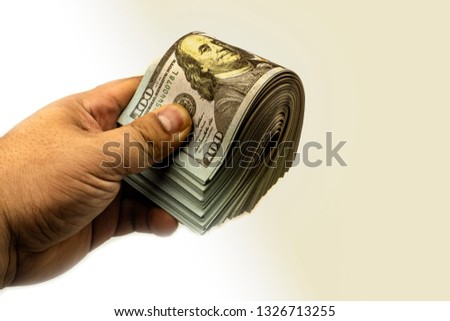 Hand holding bundles 100 American Dollar's Stack Rendering On White