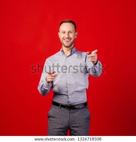 man pointing finger at you over red background. emotion and people concept.