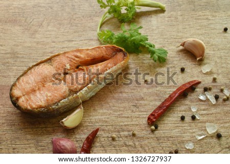 grilled salmon fish with salt and pepper on wooden background