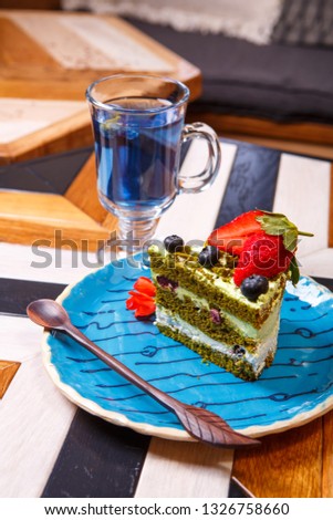 Thai blue drink tea and vegan spirulina cake on plate. Vegan menu restaurant
