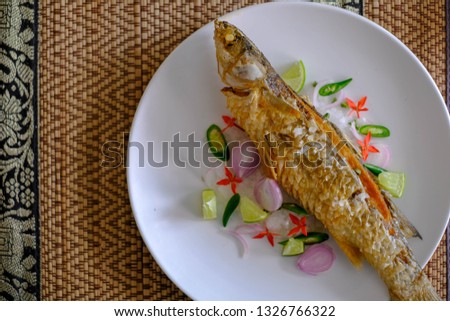 Deep fried fish season with salt and herb on mat