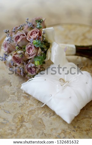 Wedding rings on a pillow and a bouquet