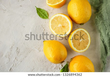 Ripe and juicy lemons with leaves on a light background. Space for text. Top view.