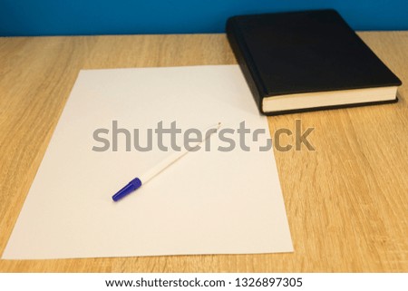 stack of books lying on top of each other wooden surface blue background