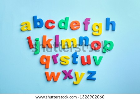 Plastic magnetic letters on color background, top view. Alphabetical order