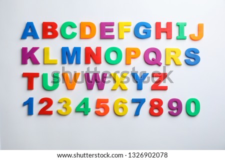 Plastic magnetic letters and numbers isolated on white, top view Royalty-Free Stock Photo #1326902078