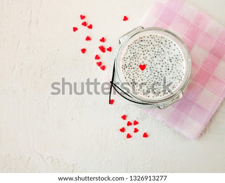 Chia seed pudding with nut milk in a glass jar on a light background. Space for text. Top view