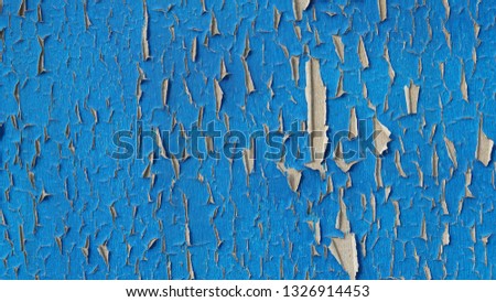 Grunge wall texture background. Paint cracking off dark wall with rust underneath