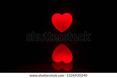 Dark table,Valentines day concept and love red shape heart with bokeh background, empty for text and placing products with copy space. Blurred glowing heart on a dark background with reflection