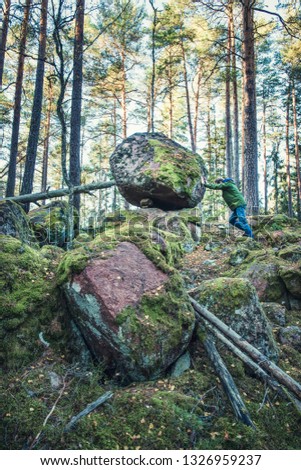 Man in forest moving rock
