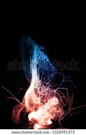 Vape clouds splash on black background. Two colours fog is blue and red. Stock isolated color smoke with spray boiling glycerine.