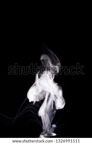 Vape steam column with spray boiling liquid. Stock photo isolated on black background. 