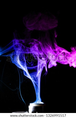Colored clouds of vape smoke. A lot of colour and glicerine clouds, red and blue colours. Stock photo isolated on black background with boling spray of vaping liquid. Vape culture and no smoking 