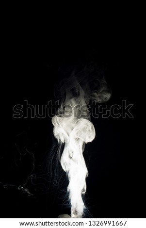 Vape steam column with spray boiling liquid. Stock photo isolated on black background. 