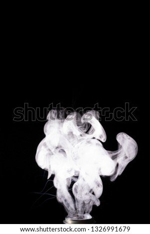 Splash glicerine on vape spiral. White thick fog with visible tracers. Vape culture and no smoking. Smoke rising up. Underexposed stock photo isolated on black background