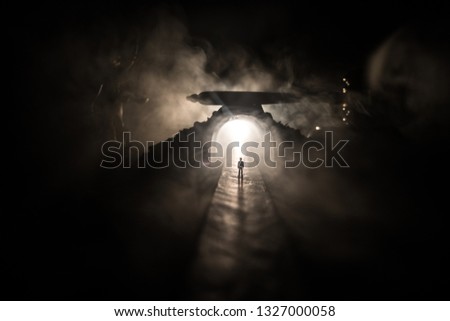 Legal law or crime concept. Man alone standing in the middle of the road on a foggy night. Artwork decoration with handcuffs, Statue of Justice and mallet of justice on toned foggy background.
