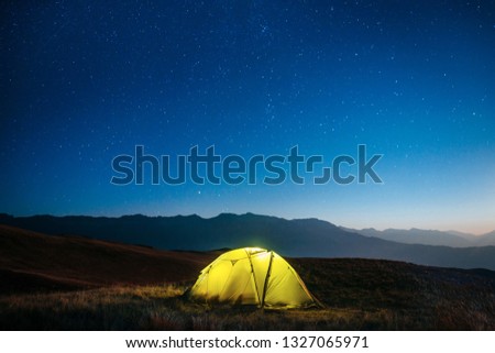 Yellow tent at night in the mountains