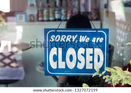 Sorry we are closed sign hanging on the door of cafe.