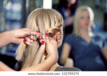Hairdresser make French braids   in beauty salon. Royalty-Free Stock Photo #132709274