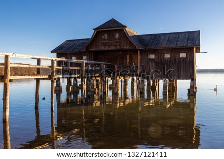 A boatshouse at a lake at sunset Royalty-Free Stock Photo #1327121411