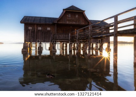 A boatshouse at a lake at sunset Royalty-Free Stock Photo #1327121414