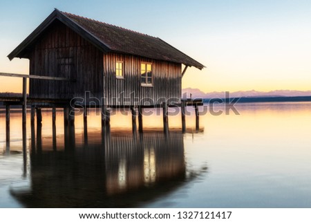A boatshouse at a lake at sunset Royalty-Free Stock Photo #1327121417