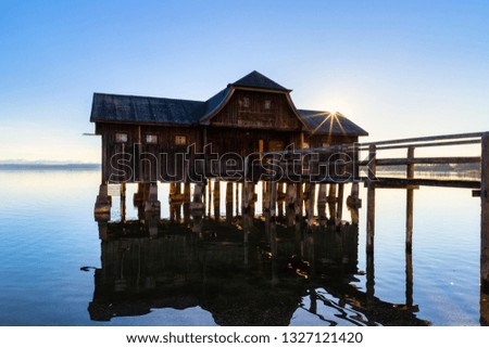 A boatshouse at a lake at sunset Royalty-Free Stock Photo #1327121420