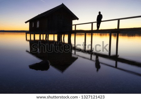 A boatshouse at a lake at sunset Royalty-Free Stock Photo #1327121423