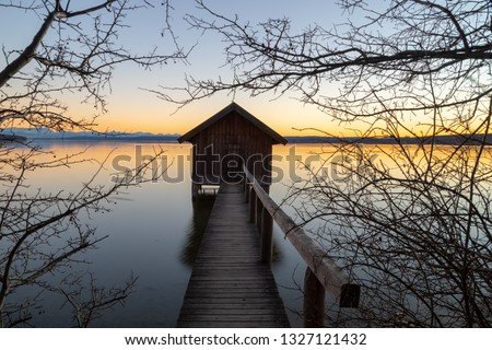 A boatshouse at a lake at sunset Royalty-Free Stock Photo #1327121432