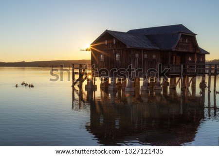 A boatshouse at a lake at sunset Royalty-Free Stock Photo #1327121435