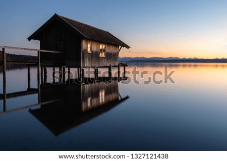 A boatshouse at a lake at sunset Royalty-Free Stock Photo #1327121438