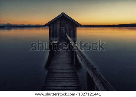 A boatshouse at a lake at sunset Royalty-Free Stock Photo #1327121441
