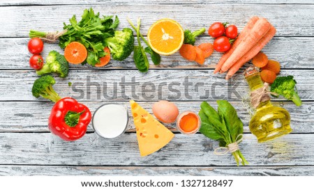 Healthy foods, fruits and vegetables. Broccoli, Carrots, milk, cheese, spinach, dried apricots, parsley, tomatoes. Top view.