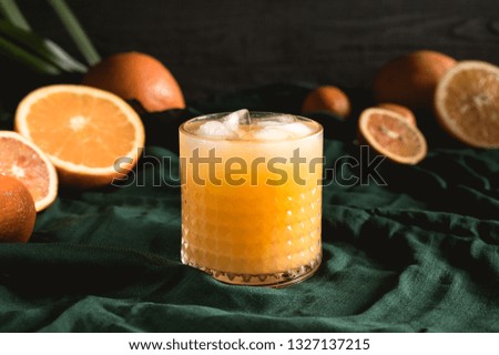 Fresh orange juice with fruits on green background
