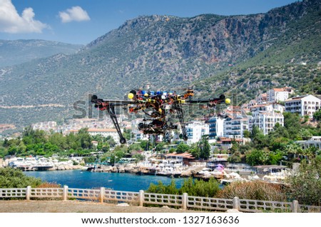 The Hexacopter (Multicopter) drone with the professional camera takes pictures the air. Uav drone copter flying with digital DSLR camera. High resolution digital camera on the sky.
