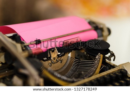 Vintage typewriter with pink paper sheet. Space for your text.