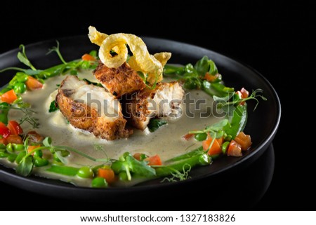 Seared Halibut fillet served in a round black plate
