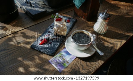 Kuwaiti banknotes lying under a cup of coffee on a table in a cafe