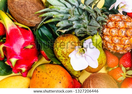 Summer background with variety of tropical fruits on yellow