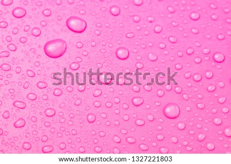 Rain water drops on pink plastic surface or grunge. 