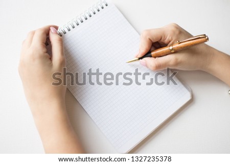 Notebook and pen in hand. Isolated on white background.gold pen in hands
