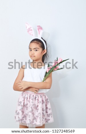 Cute little girl with easter bunny ears holding pink tulips wall bright gray background, Concept big sale spring  background
