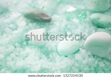 Nice picture with turquoise sea salt and several stones on it. Beautiful background. Minerals for body care and treatment. Products for spa. Close-up.