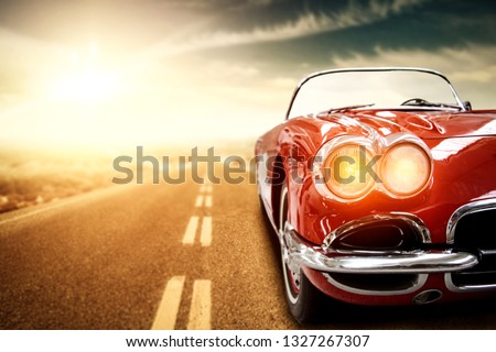 Red retro summer car on road in USA. Free space for your text.  Royalty-Free Stock Photo #1327267307