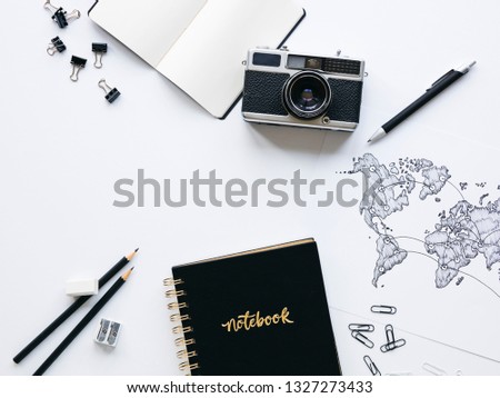 old, vintage camera with black notebook and hand-drawn world map on white background