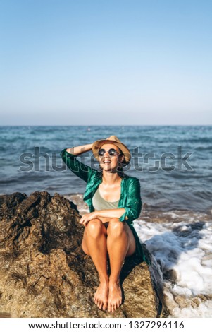 Cute pan asian girl relaxing on the beach near the sea in green pareo