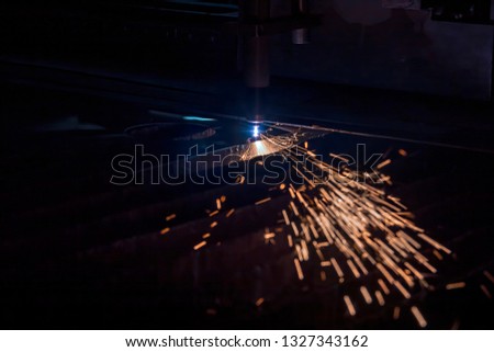 CNC Laser cutting of metal, modern industrial technology. Small depth of field. Warning - authentic shooting in challenging conditions. A little bit grain and maybe blurred