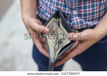 Young man Shows his wallet with a lot of money 